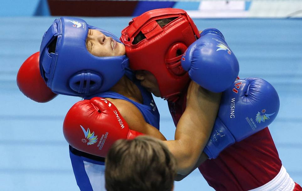 Sfida tra l’indiana Chungneijang Mery Kom Hmangte (casco rosso) e la kazaka Zhaina Shekerbekova (casco blu) nella finale di boxe femminile al Seonhak Gymnasium nei Giochi Asiatici 2014 di Incheon, Corea del Sud (Reuters)